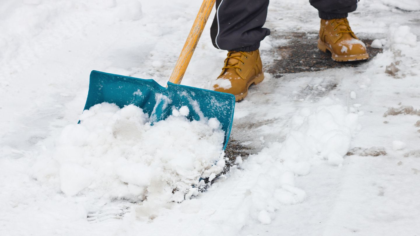 Shoveling snow from a walkway by hand